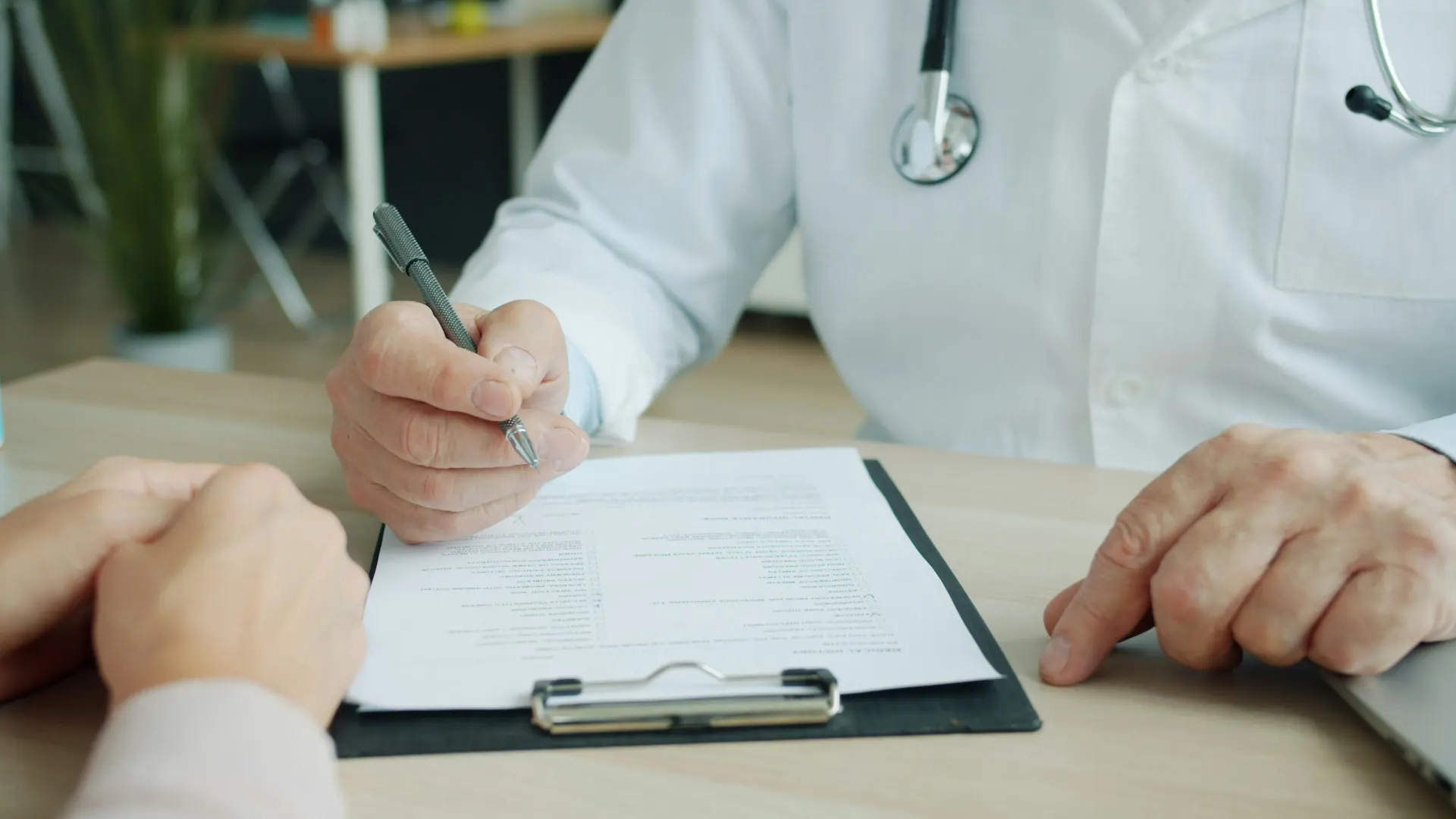 Doctor filling out lab requisition on clipboard